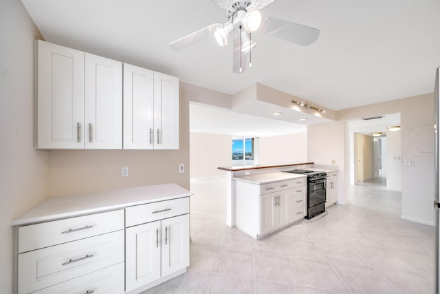 kitchen featuring white cabinets, ceiling fan, black range with electric cooktop, and kitchen peninsula