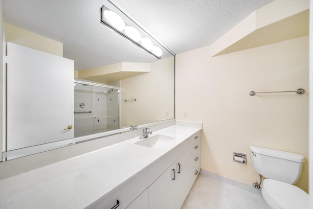 bathroom featuring toilet, a textured ceiling, walk in shower, tile patterned flooring, and vanity