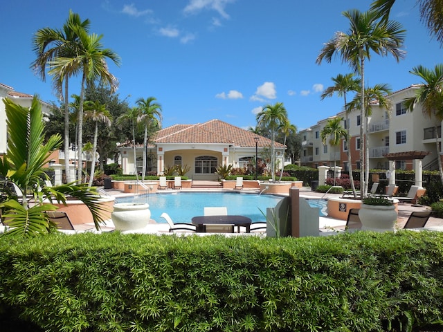 view of pool featuring pool water feature and a patio