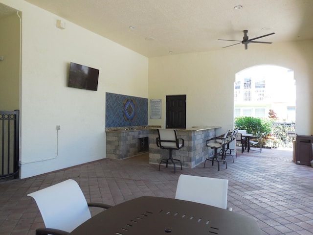 view of patio with ceiling fan and an outdoor bar