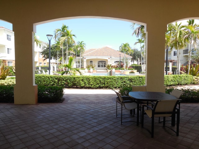 view of patio / terrace featuring ceiling fan, exterior kitchen, and an outdoor wet bar