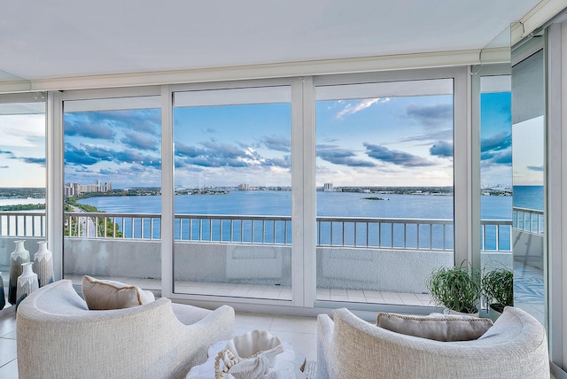 sunroom featuring a water view