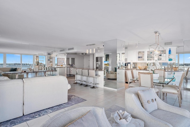 living room featuring light tile floors, plenty of natural light, and rail lighting