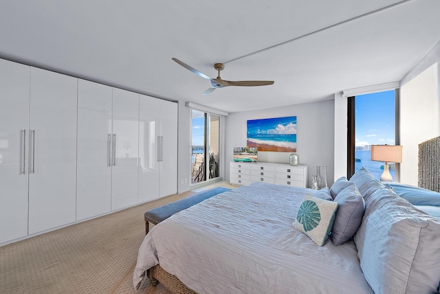 bedroom with ceiling fan, floor to ceiling windows, and light carpet