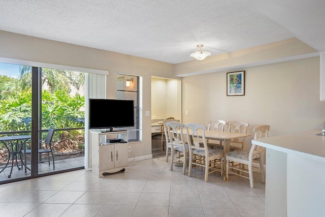 dining space with a textured ceiling and light tile flooring