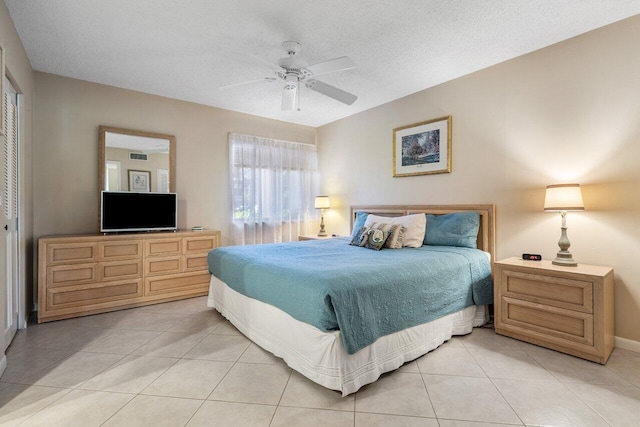 tiled bedroom with a textured ceiling, a closet, and ceiling fan