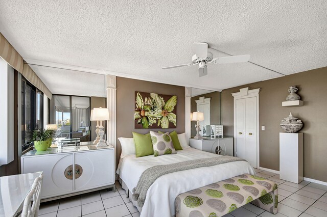 bedroom featuring ceiling fan, a textured ceiling, and light tile flooring