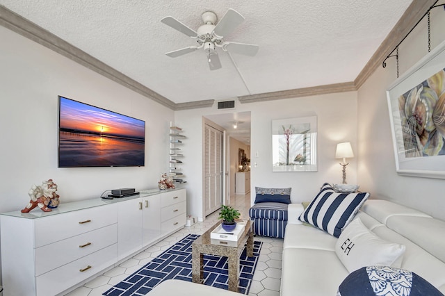 living area featuring a ceiling fan, visible vents, a textured ceiling, and ornamental molding