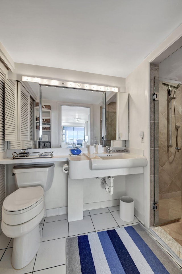 bathroom featuring a shower with shower door, toilet, and tile floors