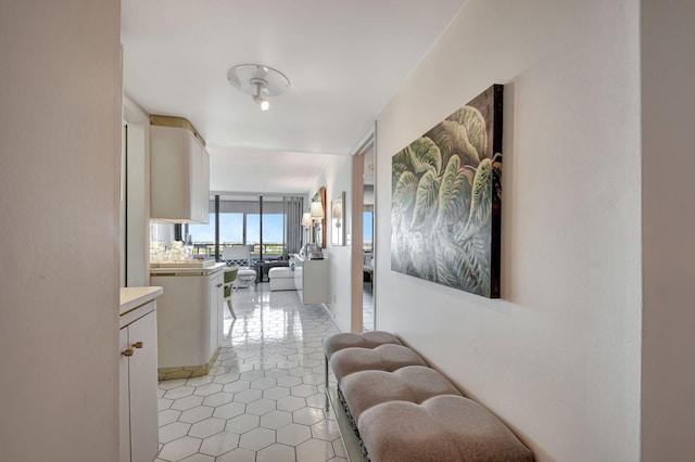 hall with floor to ceiling windows and light tile floors