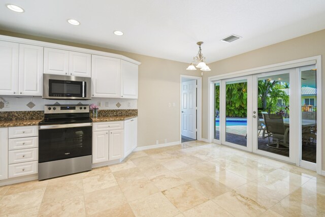 kitchen featuring dark stone counters, white cabinetry, decorative light fixtures, and stainless steel appliances