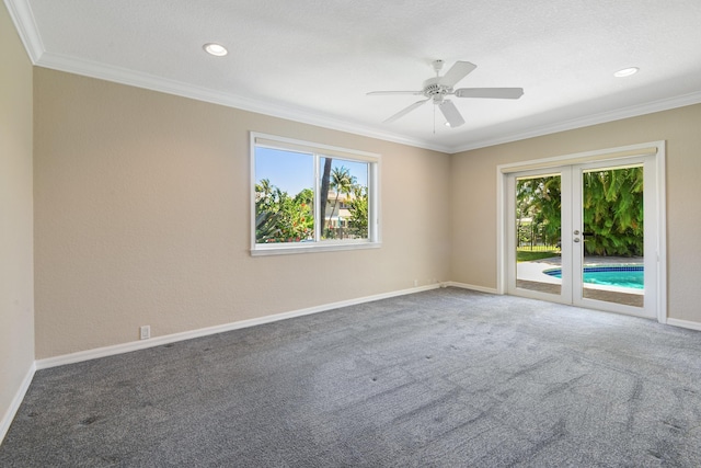 carpeted spare room featuring ornamental molding, a healthy amount of sunlight, and ceiling fan