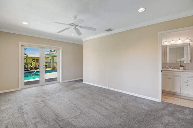 unfurnished bedroom with light carpet, ensuite bathroom, access to outside, sink, and ceiling fan