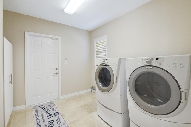 laundry area featuring washing machine and clothes dryer and light tile patterned floors