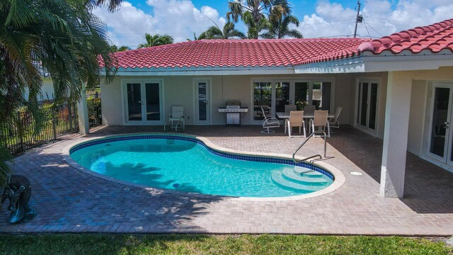 view of swimming pool featuring area for grilling, french doors, and a patio