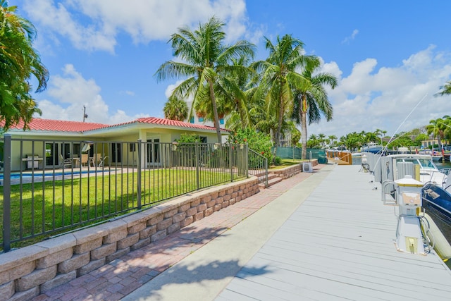 view of home's community featuring a boat dock and a lawn