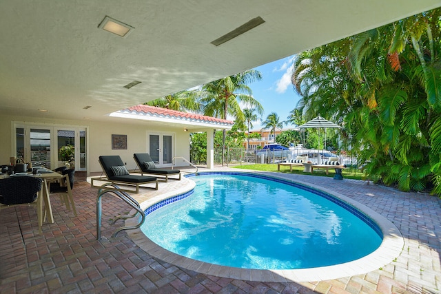 view of swimming pool featuring french doors, a patio area, and outdoor lounge area