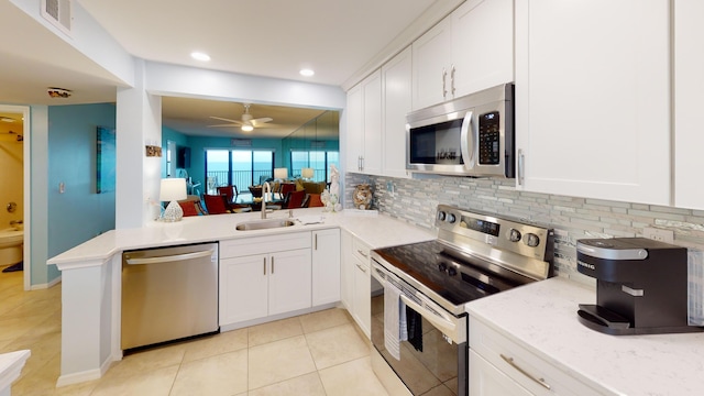 kitchen featuring kitchen peninsula, ceiling fan, white cabinets, and stainless steel appliances