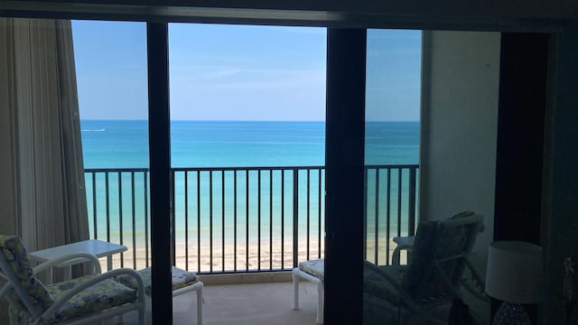 balcony with a water view and a beach view