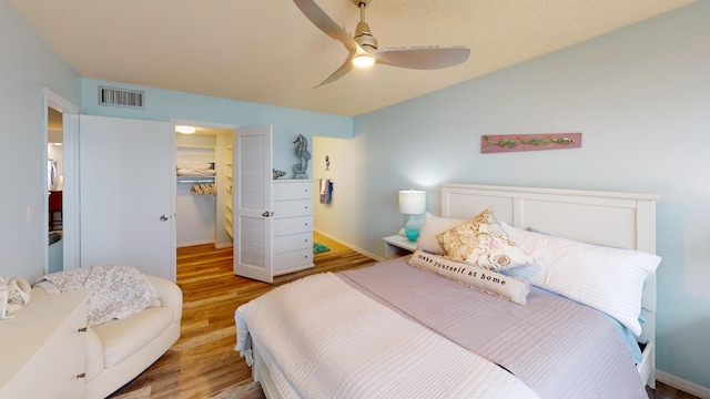 bedroom featuring ceiling fan, a closet, and light hardwood / wood-style flooring