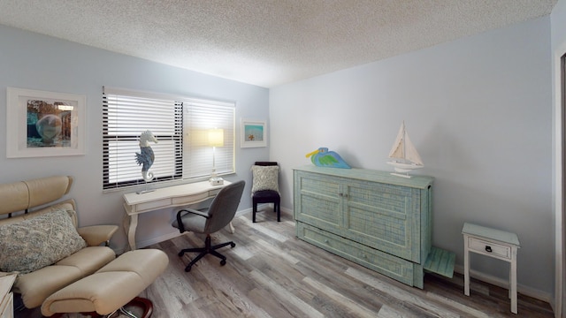 home office with a textured ceiling and light wood-type flooring