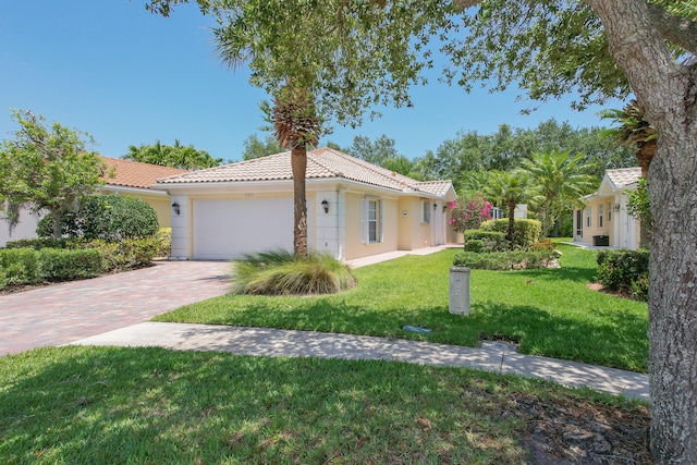 mediterranean / spanish house featuring a garage and a front lawn