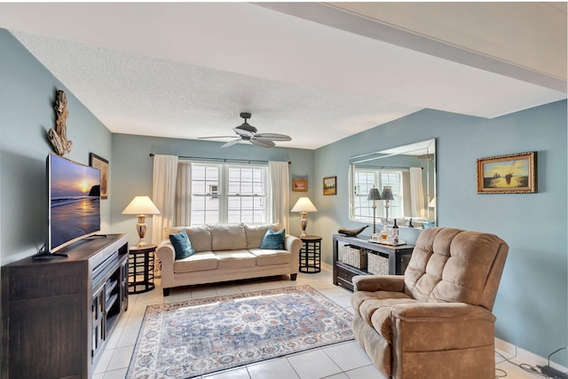 living room featuring a healthy amount of sunlight, a textured ceiling, light tile flooring, and ceiling fan