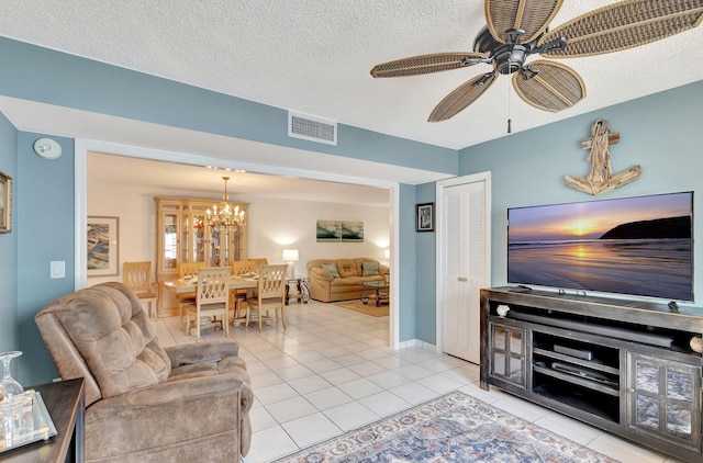 tiled living room featuring a textured ceiling and ceiling fan with notable chandelier