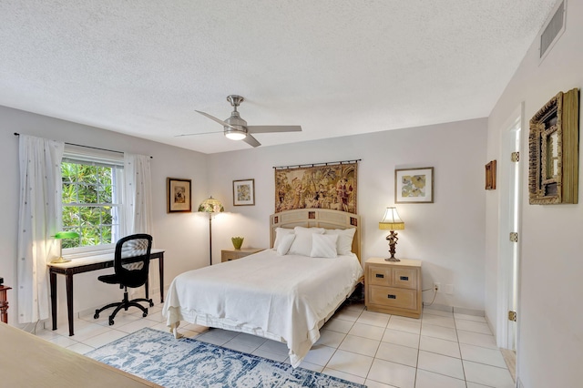 tiled bedroom with ceiling fan and a textured ceiling