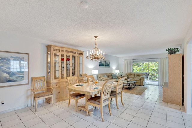 dining area featuring a notable chandelier, a textured ceiling, and light tile floors