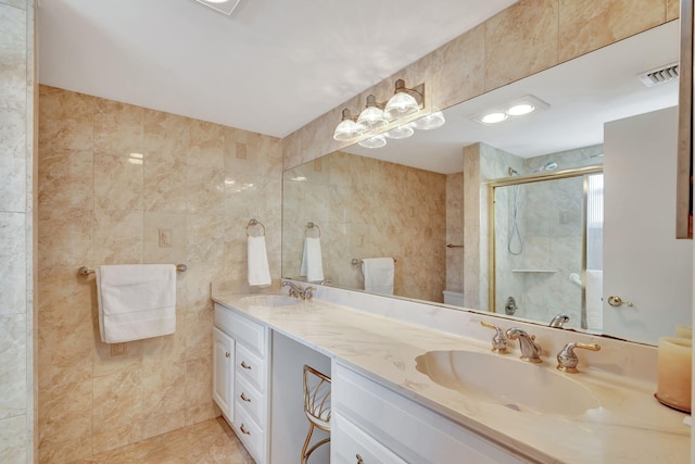 bathroom featuring tile floors, double sink, oversized vanity, and tile walls