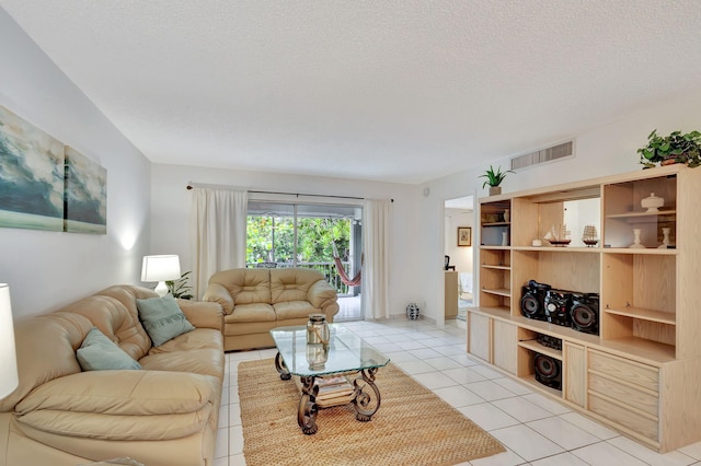 living room featuring a textured ceiling and light tile floors