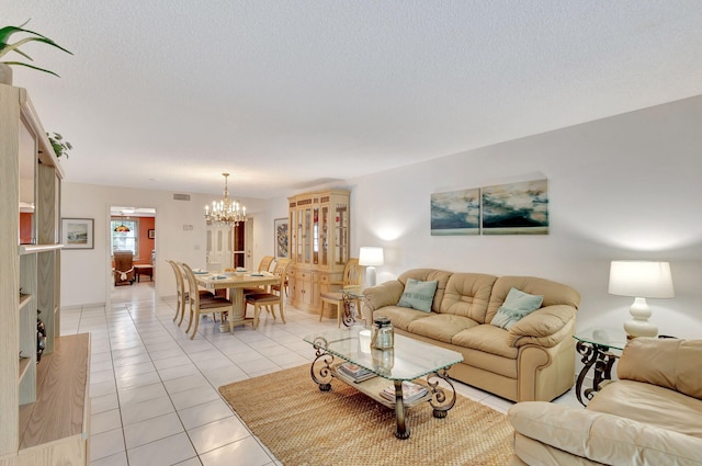 living room featuring a textured ceiling, light tile flooring, and an inviting chandelier