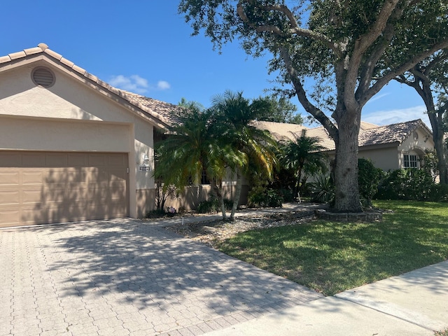 view of front of house with a garage and a front lawn