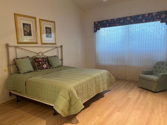 bedroom with lofted ceiling and light hardwood / wood-style floors