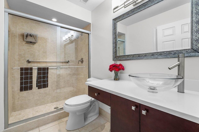 bathroom with tile patterned floors, vanity, toilet, and a shower with door