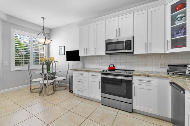 kitchen featuring tasteful backsplash, decorative light fixtures, light tile patterned flooring, white cabinetry, and stainless steel appliances