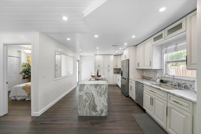 kitchen featuring dark hardwood / wood-style floors, sink, stainless steel appliances, and light stone countertops