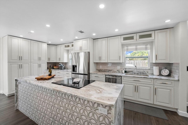 kitchen with stainless steel appliances, white cabinetry, dark hardwood / wood-style floors, sink, and a kitchen island