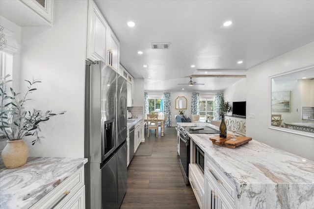 kitchen featuring appliances with stainless steel finishes, ceiling fan, white cabinetry, and dark hardwood / wood-style floors