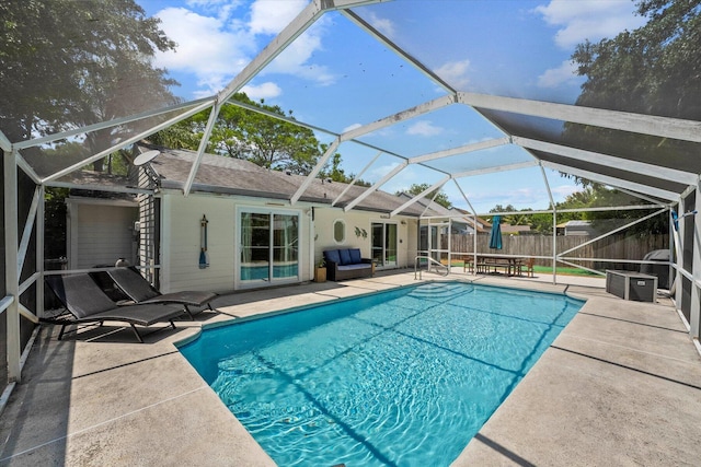 view of pool with glass enclosure and a patio area