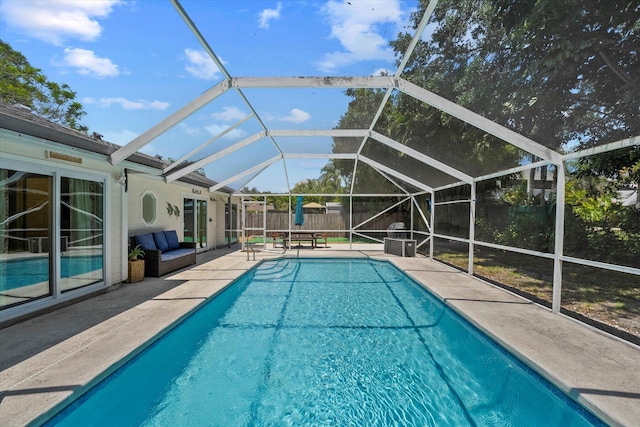 view of pool with a patio area and glass enclosure