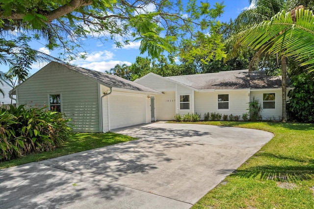 ranch-style home featuring a garage and a front lawn