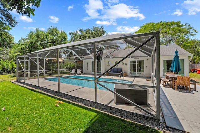 view of pool featuring a patio, glass enclosure, and a yard