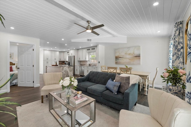 living room with ceiling fan, wooden ceiling, light wood-type flooring, and beamed ceiling