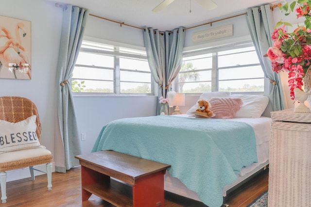 bedroom with ceiling fan, wood-type flooring, and multiple windows