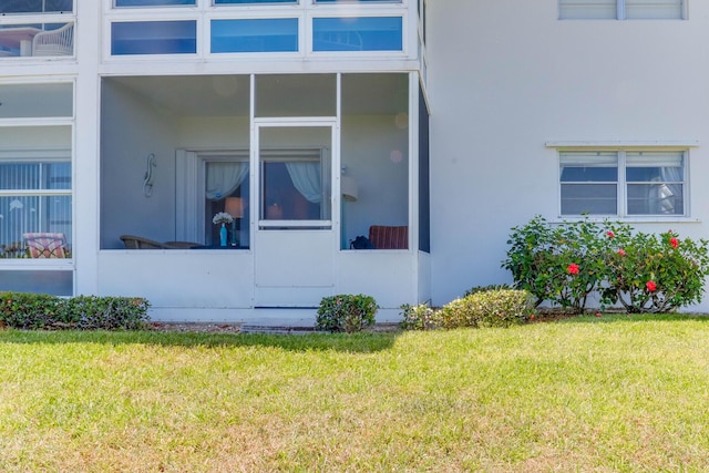 view of side of property featuring a sunroom and a yard