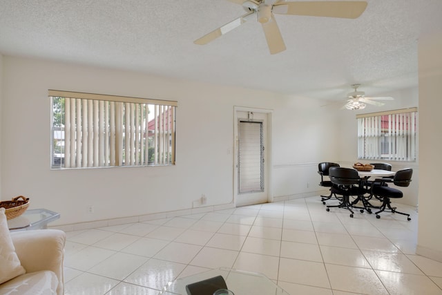 tiled dining room featuring ceiling fan and a textured ceiling