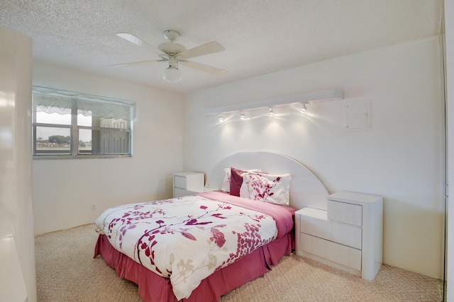 carpeted bedroom featuring a textured ceiling and ceiling fan