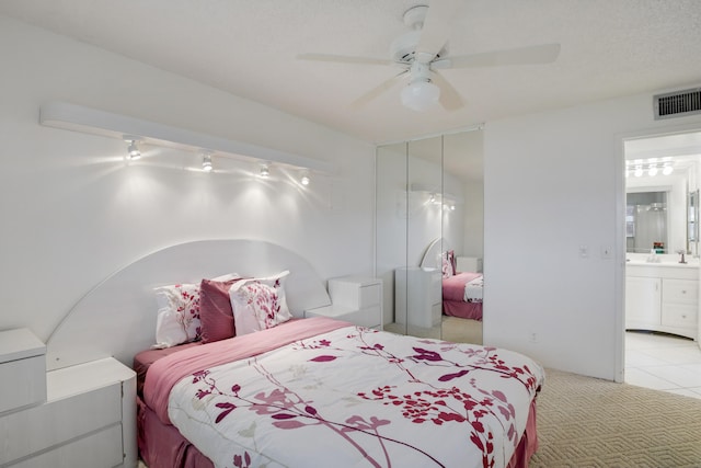 tiled bedroom featuring sink, ensuite bathroom, and ceiling fan